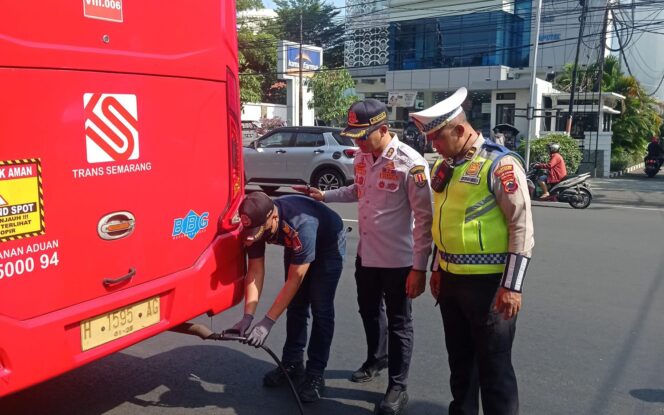 
					Petugas Dishub dibantu personel Polrestabes Semarang melaksanakan uji emisi armada BRT Trans Semarang, Selasa (11/6/2024).
