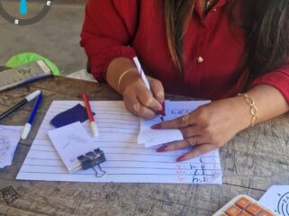 Seorang perempuan berbaju merah terlihat sedang melayani pembelian kupon togel 