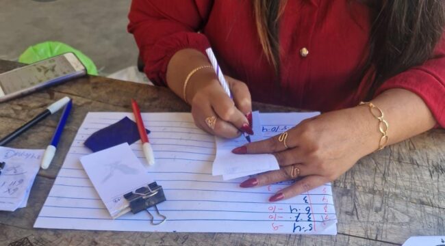 Seorang perempuan berbaju merah terlihat sedang melayani pembelian kupon togel 