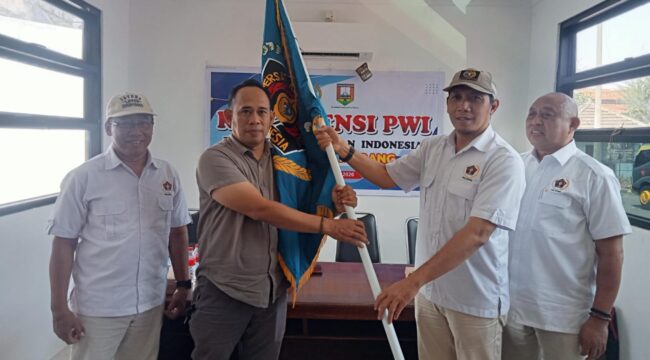 Ketua PWI Jateng Setiawan Hendra Kelana menyerahkan bendera pataka PWI kepada Ketua terpilih Rony Yuwono. (Foto: Kabarjateng.id / Mualim)