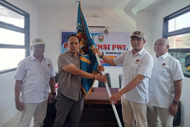 
					Ketua PWI Jateng Setiawan Hendra Kelana menyerahkan pataka PWI kepada Ketua terpilih Rony Yuwono. (Foto: Kabarjateng.id / Mualim)